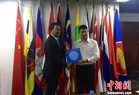 中國—東盟博覽會秘書處副秘書長黃平西（右）與柬埔寨新聞部新聞與傳播總司副總司長春占皮侖（左）互贈禮物。